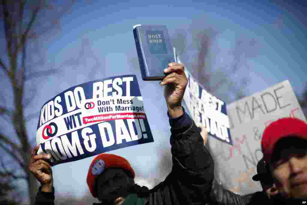 A demonstrator holds a bible while marching outside the Supreme Court in Washington as the court heard arguments on California's Proposition 8, March 26, 2013.