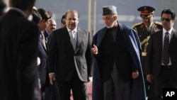 Afghan President Hamid Karzai, center right, talks with Pakistan Prime Minister Nawaz Sharif while they inspect honor guard, Kabul, Nov. 30, 2013.