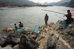 FILE - Fishermen lay out their nets on the Mekong River near Luang Prabang close to the site of an approved Laos dam site, Feb. 8, 2020.