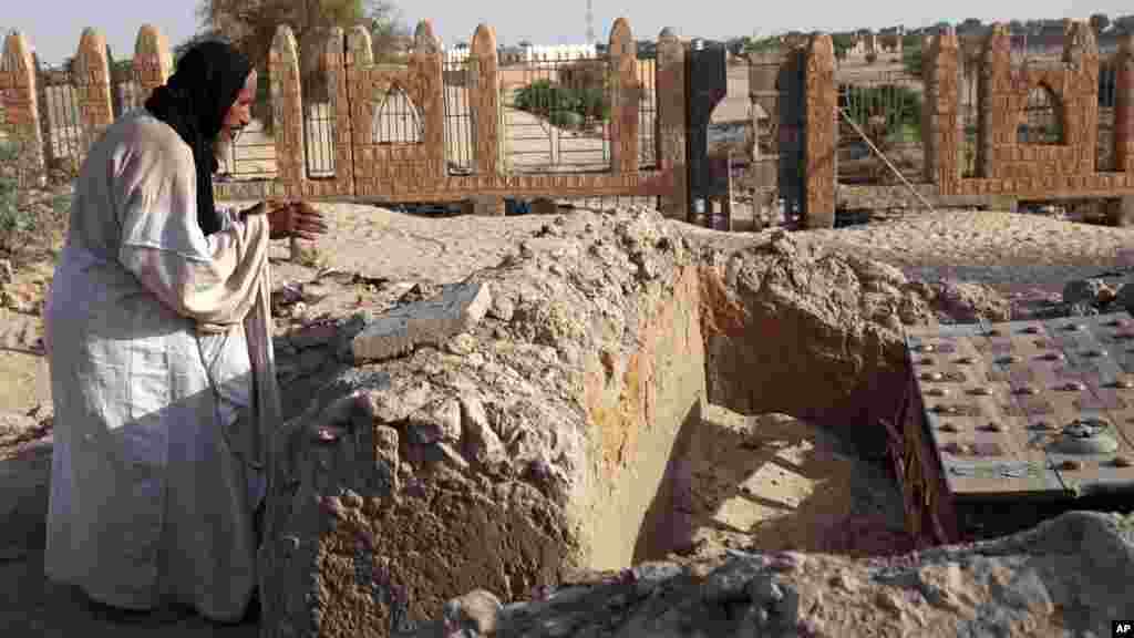 Mohamed Maouloud Ould Mohamed, le preneur de soin des tombes de Tombouctou, prie sur l'une des tombes, le 4 avril 2014.