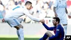 À gauche, Cristiano Ronaldo, alors au Real Madrid, aide le Lionel Messi de Barcelone à se relever lors du match de football espagnol La Liga entrele Real Madrid à Barcelone, au stade Santiago Bernabeu de Madrid, Espagne, 23 décembre 2017.