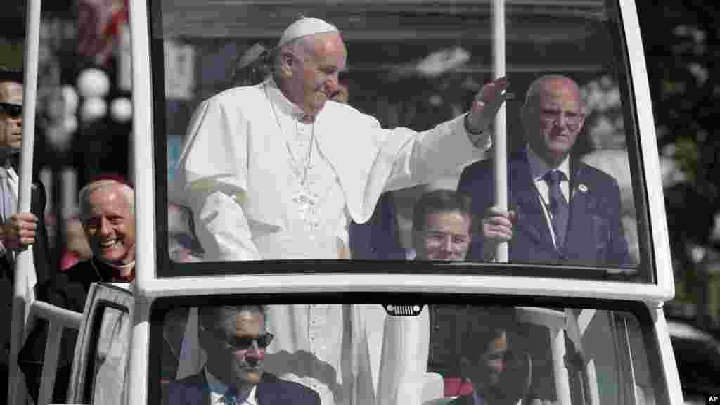 Le cardinal Donald Wuerl, archevêque de Washington, à gauche, sourit, à bord de la papa mobile d'où le pape François salue la foule à Washington, 23 septembre 2015.