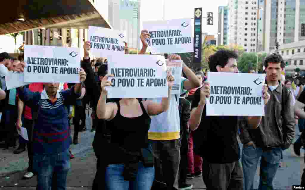 Warga membawa kertas bertuliskan "Pekerja Metro: Rakyat mendukungmu," di luar stasiun kereta bawah tanah Ana Rosa pada pemogokan hari ke lima di Sao Paulo, Brazil (9/6).