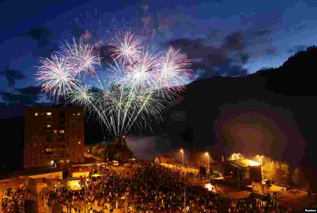 People watch fireworks explode above the Yenisei River in the town of Divnogorsk near Russia's Siberian city of Krasnoyarsk. The display was performed to mark Russia Day, the national holiday of the Russian Federation, also the Day of the Town.