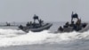 FILE - U.S. and Philippine Navy servicemen aboard patrol boats conduct a boat manoeuvre exercise past a fishing boat during a joint annual military exercise called "Carat" at the former U.S. military base Sangley Point in Cavite city, west of Manila, June