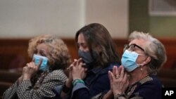 Women pray, June 26, 2021, during a prayer vigil for the victims and families of the Champlain Towers collapsed building in Surfside, Fla., at the nearby St. Joseph Catholic Church in Miami Beach, Fla.