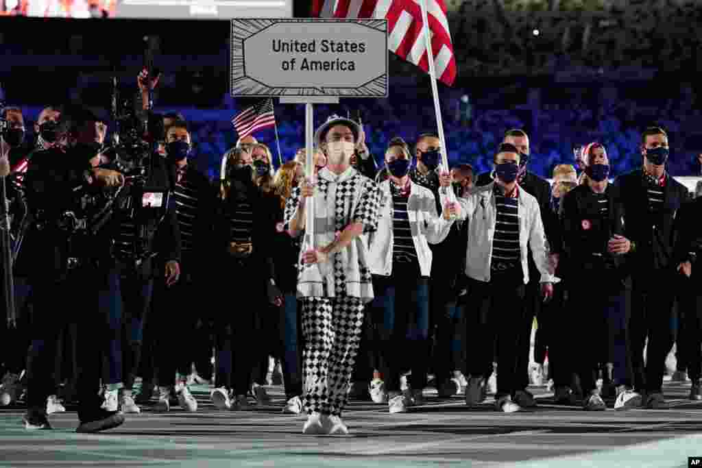 Sue Bird and Eddy Alvares, of the U.S., carry their country's flag during the opening ceremony in the Olympic Stadium at the 2020 Summer Olympics, July 23, 2021, in Tokyo, Japan.