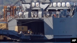 FILE - A truck carrying a container from the Danish vessel Ark Futura drives into the hold of the U.S.-owned MV Cape Ray, at Gioia Tauro port, southern Italy, July 2, 2014.