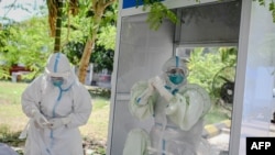 ရန်ကုန်မြို့ရှိ Quarantine စင်တာတခုမှာ COVID 19 ရှိ၊ မရှိ စစ်ဆေးပေးဖို့ ပြင်ဆင်နေကြတဲ့ ကျန်းမာရေးဝန်ထမ်းများ။ (မေ ၁၆၊ ၂၀၂၀)