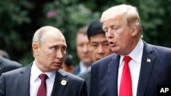 FILE - U.S. President Donald Trump and Russia's President Vladimir Putin talk during a photo session at the APEC Summit in Danang, Vietnam, Nov. 11, 2017. 