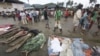 Residents pass by bodies recovered from flashflood in New Bataan, Compostela Valley province, southern Philippines, December 5, 2012.
