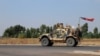 FILE - A U.S. military vehicle, part of a convoy, arrives near Dahuk, Iraqi, Oct. 21, 2019.