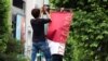 Workers attach the Tokyo 2020 Olympic Games banner on a lamp post in Tokyo, Japan, June 16, 2021. 