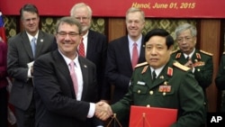 U.S. Defense Secretary Ash Carter, front left, shakes hands with his Vietnamese counterpart Gen. Phung Quang Thanh, front right, after the two signed a joint vision statement between the two defense ministries in Hanoi, Vietnam Monday, June 1, 2015. (AP Photo/Tran Van Minh)
