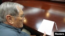 Foto yang dirilis oleh Kantor Berita Resmi Korea Utara (KCNA), menunjukkan Merrill E. Newman, warga AS menorehkan cap jempolnya di sebuah kertas sesaat setelah ditangkap di Korea Utara (30/11).