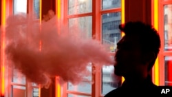 ARSIP – Seorang pelanggan menghembuskan uap dari rokok elektronik di sebuah toko di New York, 20 Februari 2014, (foto: AP Photo/Frank Franklin II, Arsip)