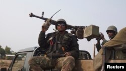 FILE - Congolese government army soldiers ride on their truck as they patrol Kibati village outside the eastern Congolese city of Goma, DRC. 