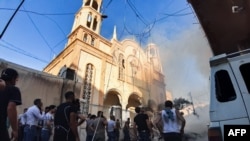Warga berkumpul di sekitar lokasi ledakan bom mobil di luar Gereja Ortodoks "Virgin Lady" di kawasan al-Wasti, kota Qamishli di Suriah timur laut, 11 Juli 2019.
