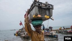 Les hommes pêchent une prise d'un jour, principalement le plus petit poisson sardinelle, au large de Joal, au Sénégal, le 29 mai 2017. (R. Shryock / VOA)