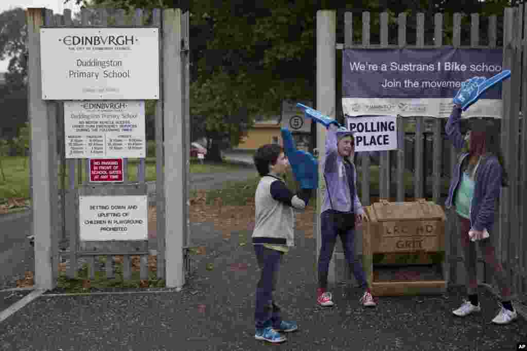 Anak-anak bermain di luar tempat pemungutan suara di Edinburgh, Skotlandia (18/9). (AP/Matt Dunham)