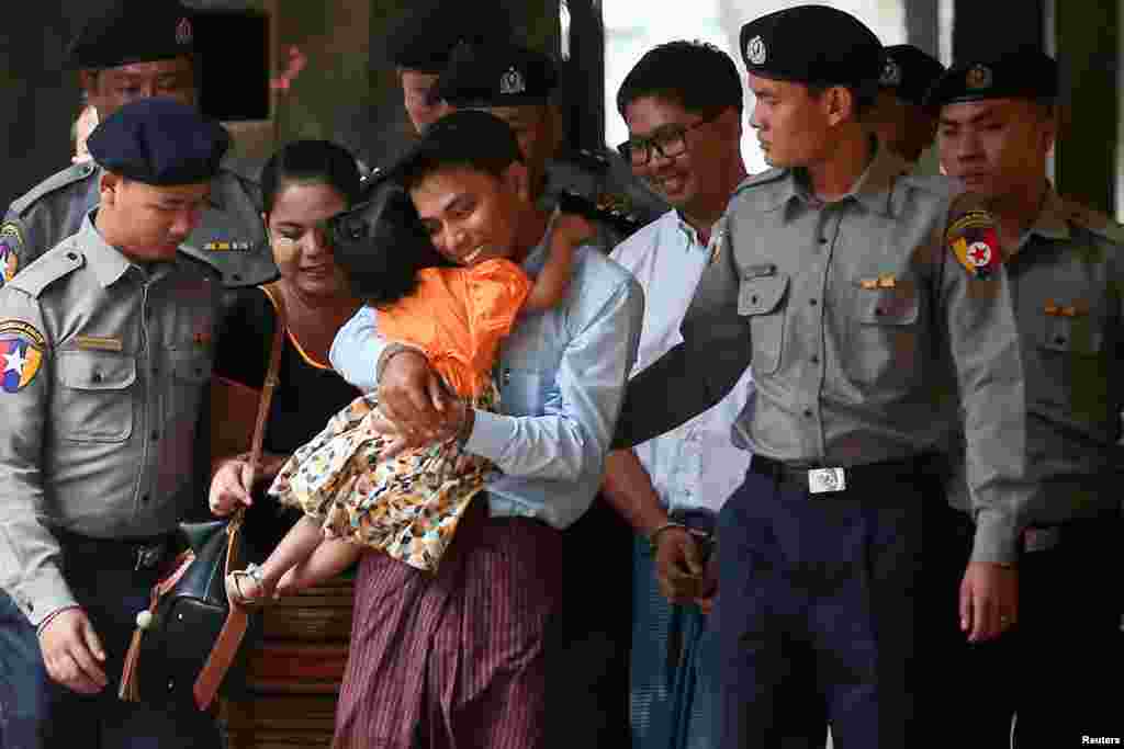 លោក Kyaw Soe Oo អ្នកកាសែត Reuters ដែលត្រូវបានចាប់ខ្លួន អោបកូនស្រីរបស់ខ្លួនខណដែលលោកត្រូវប៉ូលិសបញ្ជូនមកតុលាការនៅក្នុងទីក្រុងរ៉ង់ហ្គូនប្រទេសមីយ៉ាន់ម៉ា។