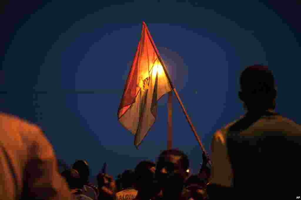 Un manifestant tient un drapeau national du Burkina Faso lors d'une manifestation contre le coup d'État récent à Ouagadougou, Burkina Faso, 21 septembre 2015.
