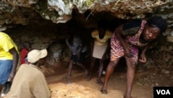 People emerge from a cave near Jeremie, Haiti, where scores continue to seek shelter after their homes were damaged or destroyed by Hurricane Mathew last October. (B. Magloire for VOA)