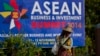 A sweeper cleans a road in the foreground of a billboard promoting Association of Southeast Asian Nations (ASEAN) summit in Naypyitaw, Myanmar, Tuesday, Nov 11, 2014. Myanmar hosts the ASEAN summit and related meetings on Nov. 12 and 13. (AP Photo/Gemunu 