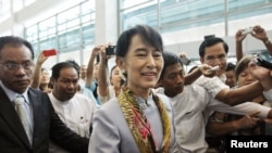 Myanmar's pro-democracy leader Aung San Suu Kyi makes her way through the Yangon International Airport as she leaves for her trip to Europe June 13, 2012.