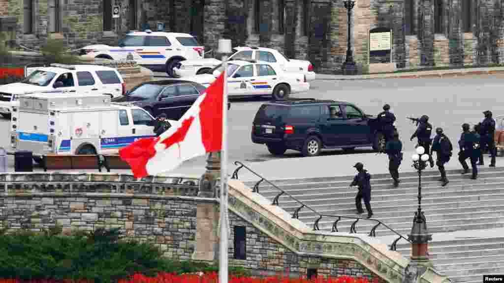 Des agents de la GRC, armés jusqu'aux dents, lancent un assaut à l'édifice du Parlement après une fusillade à Ottawa, le 22 Octobre 2014.