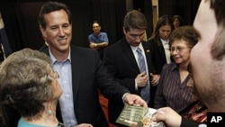 Republican presidential candidate former Pennsylvania Sen. Rick Santorum hands back an autographed campaign flyer at a rally in Shreveport, Louisiana, March 23, 2012. 