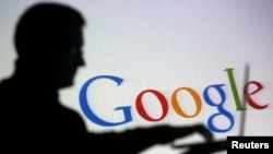 ARSIP - Silhouette seseorang saat berpose dengan laptop di depan layar dengan proyeksi logo Google, dalam sebuah ilustrasi gambar (foto: REUTERS/Dado Ruvic)