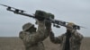Para pilot sedang membawa drone di tempat latihan di wilayah Kyiv pada 23 Februari 2024, di tengah invasi Rusia ke Ukraina. (Foto: AFP)