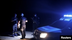 Police officers check the documents of a civilian during a night patrol after curfew, as Russia's attack on Ukraine continues, in Kramatorsk, Ukraine, Aug. 5, 2022. 