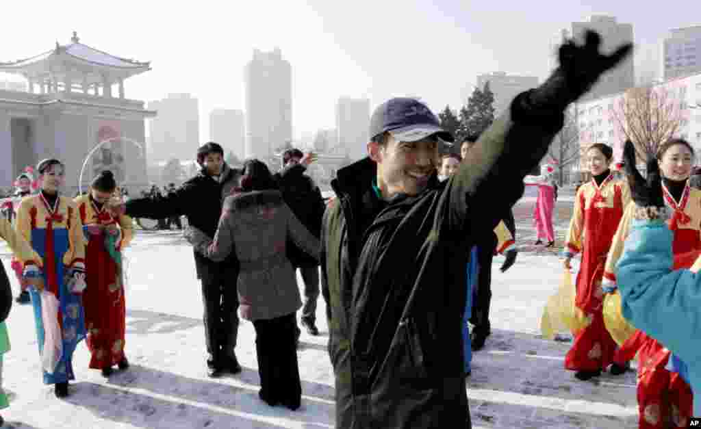Youths dance in front of the Pyongyang Grand Theater in Pyongyang, North Korea, December 12, 2012.