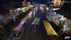 This picture taken on March 28, 2015 shows boats carrying visitors along the Amphawa canal, a small tributary of the Mae Khlong River, in Samut Songkhram province some 80 kilometers west of Bangkok. 
