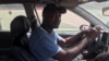 Modou Fall au volant de sa voiture, à Dakar, le 9 décembre 2019. (VOA/Seydina Aba Gueye)
