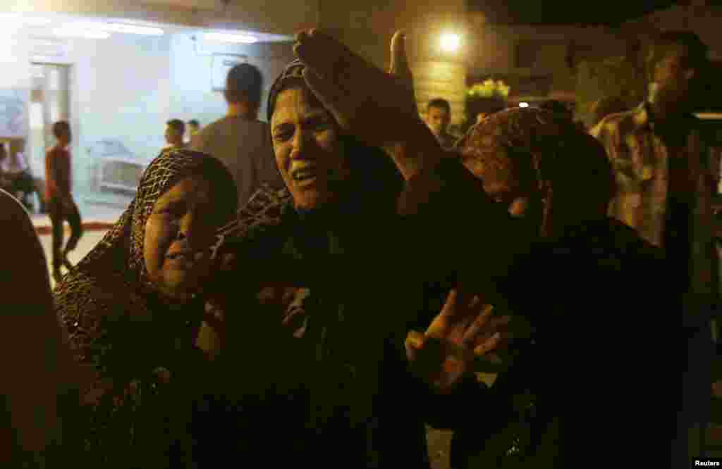 Women mourn after an Israeli air strike killed two Palestinian militants, at a hospital morgue in the central Gaza Strip, July 6, 2014.