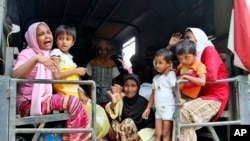 Ethnic Rohingya women and children whose boats were washed ashore on Sumatra Island board a military truck to be taken to a temporary shelter in Seunuddon, Aceh province, Indonesia, Sunday, May 10, 2015.
