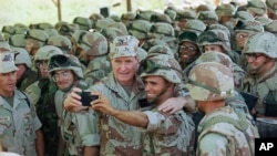  Rais George H. Bush akijipiga picha ya selfie akiwa na wanajeshi wa majini uwanja wa ndege wa Baidoa, Januari 1, 1993, Baidoa.