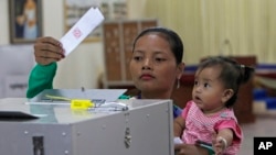 Seorang perempuan Kamboja memasukan surat suara pada pemilihan anggota senat di tempat pemungutan suara di Takhmau, Provinsi Kandal, tenggara of Phnom Penh, Kamboja, 25 Februari 2018. Pemilu akan berlangsung Juli.