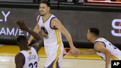 Le Golden State Warrior Klay Thompson avec ses coéquipiers Draymond Green, à gauche, et Stephen Curry, à droite, Oakland, Californie, le 2 juin 2016.