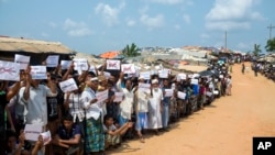 Pengungsi Rohingya memegang plakat saat menunggu kedatangan tim Dewan Keamanan PBB di kamp pengungsi Kutupalong Rohingya di Kutupalong, Bangladesh, 29 April 2018.