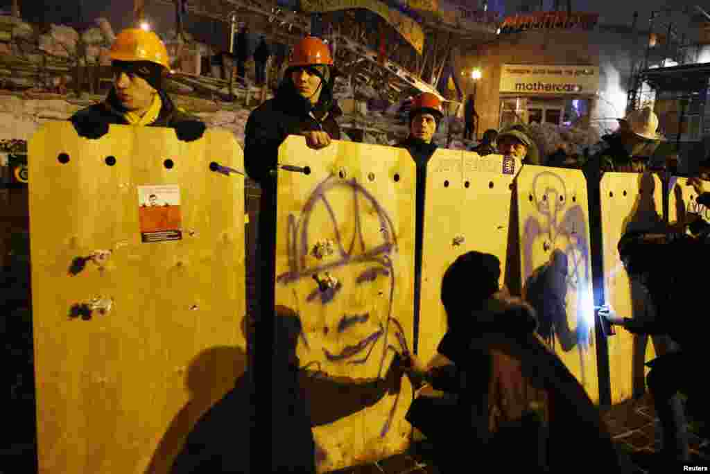 Seorang demonstran pro-integrasi Eropa melukis potret dengan menggunakan cat semprot di perisai kerusuhan darurat Lapangan Kemerdekaan di Kiev, 16 Desember 2013.