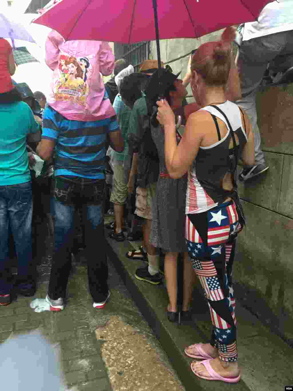 Cubans wait in the rain to catch a glimpse of U.S. President Barack Obama in Havana, Cuba. (V. Macchi / VOA)