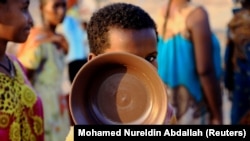 Un enfant éthiopien qui a fui les combats dans la région du Tigré fait la queue pour une ration de nourriture au camp de Um-Rakoba, à la frontière entre le Soudan et l'Ethiopie dans l'Etat d'Al-Qadarif, au Soudan, le 19 novembre 2020.