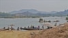 FILE - Local villagers travel on the Mekong River near Nong Khai, Thailand. The Xayaburi dam upstream generateds hydropower for he region. (Steve Sandford/VOA)