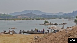 FILE - Local villagers travel on the Mekong River near Nong Khai, Thailand. The Xayaburi dam upstream generateds hydropower for he region. (Steve Sandford/VOA)