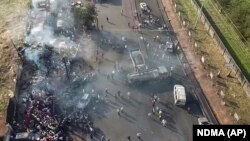 Des personnes se rassemblent autour d'un camion-citerne calciné qui a explosé après avoir été heurté par un camion dans la banlieue de Wellington, dans la capitale de la Sierra Leone, Freetown, samedi 6 novembre 2021. 