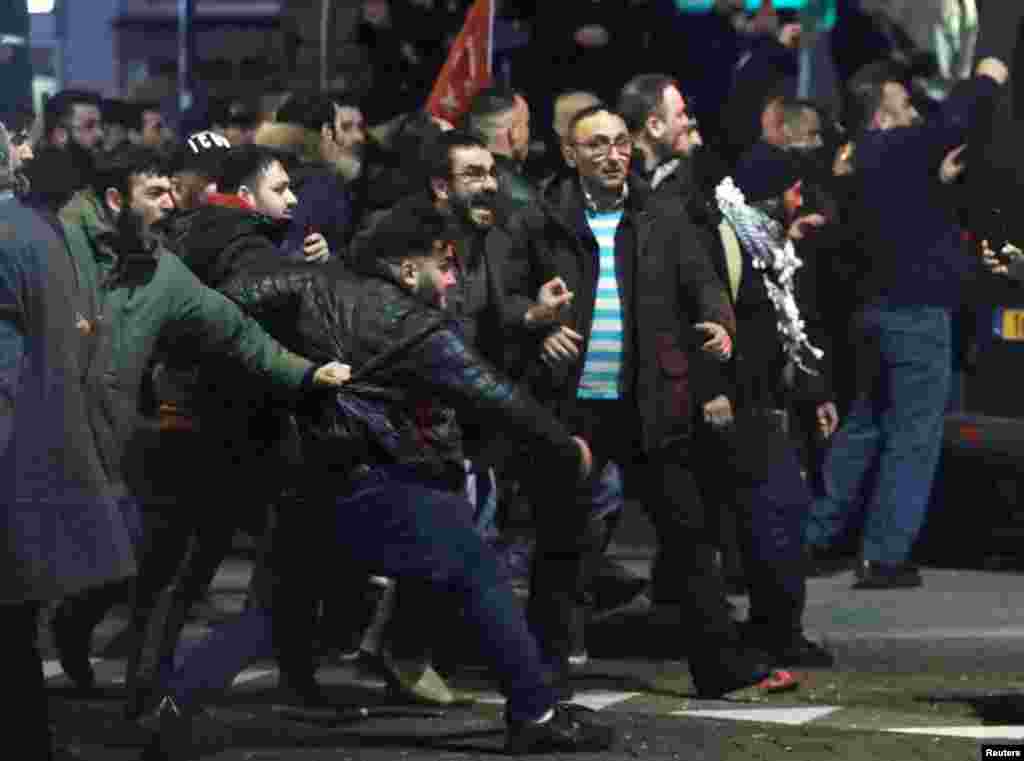 Demonstrators face Dutch riot police outside the Turkish consulate in Rotterdam, Netherlands, March 12, 2017.